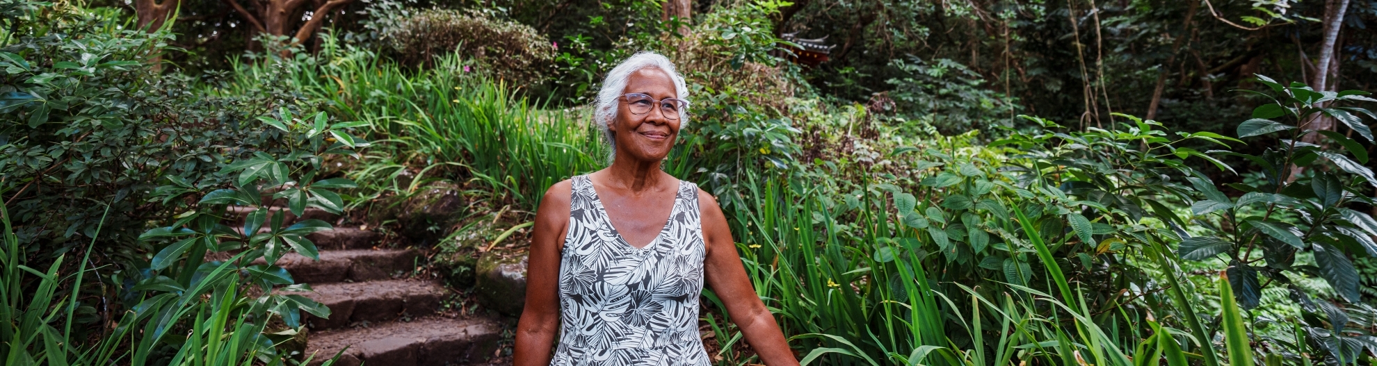 Pacific Islander senior woman on forest bathing hike in Hawaii